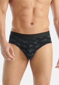 Černé spodní prádlo ve stylu šortek s geometrickým vzorem v tmavě zelené barvě. Disponuje hladkým elastickým pasem a přiléhavým střihem.