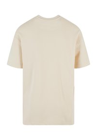 Beige katoenen T-shirt met een ronde hals en korte mouwen. De achterkant heeft een gladde, effen textuur zonder ontwerpkenmerken.