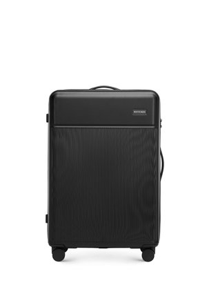 Black suitcase with a ribbed texture, hard shell design, top handle, and four wheels for mobility. Features a logo on the front panel.