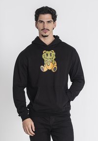 Hoodie nero con un grafico vivace di un orso sul petto, con una tasca frontale e polsini e orlo a coste. Tessuto liscio.