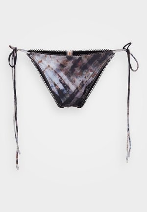Bikini de fondo con un lazo a cada lado, que presenta un patrón abstracto multicolor sobre un fondo negro y bordes decorativos en forma de concha.