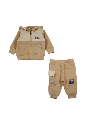 Ensemble deux pièces beige et crème pour tout-petit avec veste à capuche zippée et pantalon assorti, avec poches et logos Lee Cooper.