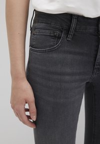 Jeans in denim grigio scuro con vestibilità slim, featuring design a cinque tasche, cuciture visibili e vita alta con un bottone in ottone in vita.