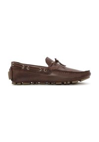Zapato mocasín de cuero marrón con superficie texturizada, parte frontal con cordones y suela de goma con pequeñas protuberancias para agarre. Vista lateral.
