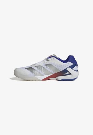 Chaussure de sport blanche avec tige en mesh, trois bandes argentées, accents bleus et rouges au talon, semelle texturée pour une meilleure adhérence, design ergonomique moderne.