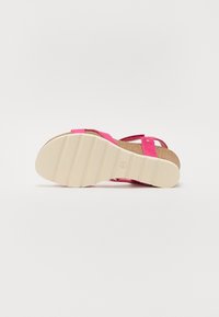 Sandali di sughero rosa con fasce regolabili e suola in gomma caratterizzata da sottili scanalature per una presa migliore. La soletta è realizzata in sughero texturizzato.