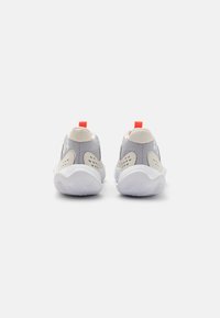 Grå mesh sneakers har hvide såler, kontrasterende beige accenter og en rød trækløkke på hælen med perforerede detaljer på siderne.