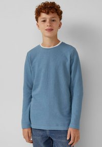 Lange mouwen blauwe katoenen shirt met een ronde hals, voorzien van een witte binnenkraag. Gladde textuur, ontspannen pasvorm en eenvoudig ontwerp.
