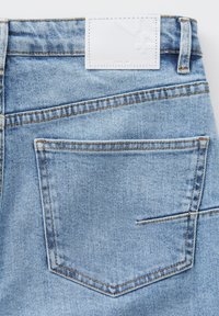 Jeans in denim azzurro chiaro con una toppa in pelle bianca con logo in rilievo, taglio dritto e design classico delle tasche posteriori con cuciture a contrasto.