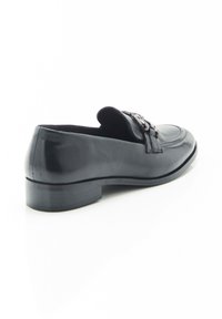 Zwarte leren loafers met een licht verhoogde hak, voorzien van een decoratieve accenten over de bovenkant en een gladde afwerking.