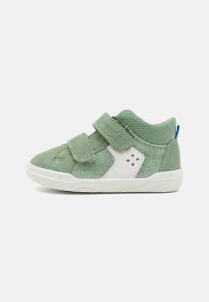 Green children's shoes featuring a mix of smooth and textured materials, Velcro straps, white accents, and a padded collar for comfort.