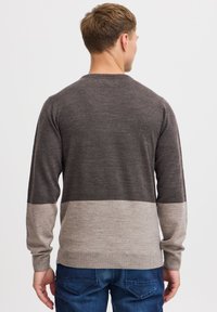 Herrenpullover im Farbblockdesign in Dunkelgrau und Hellgrau. Aus weichem Strickmaterial mit langen Ärmeln und geripptem Saum.