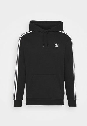 Zwarte hoodie met witte strepen aan de zijkanten, kangoeroezak en een klein wit logo op de borst. Zachte katoenmix.