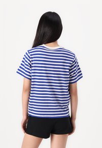 Camiseta a rayas en azul y blanco, de manga corta, con cuello redondo, material de algodón, corte holgado, con dobladillo recto.