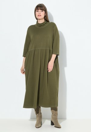 Olivgrünes, Baumwollmischkleid mit hohem Cowl-Hals, Dreiviertelärmeln und geraffter Taille, das unter die Knöchel reicht.