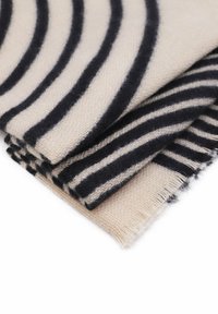 Coperta a righe in crema e blu navy, realizzata in materiale morbido. Presenta strisce larghe e distinte con bordi sfrangiati per un effetto di texture.