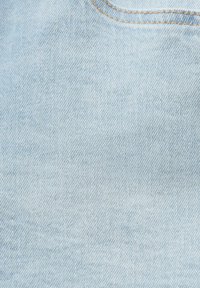 Tela de mezclilla azul claro con una textura suave, que presenta un patrón de tejido diagonal y costuras contrastantes a lo largo de las costuras.