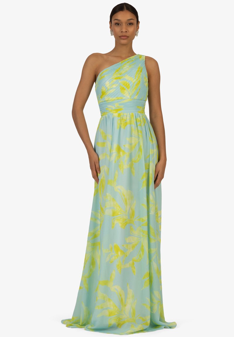 Eén-schouder vloeiende jurk in pastelblauw met gele bladerenpatronen; verzamelde taille, zachte stof en ontwerp tot op de grond.
