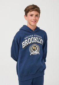Granatowa bluza z kapturem wykonana z miękkiego materiału, z nadrukiem na przodzie przedstawiającym napisy "BROOKLYN", "STANY ZJEDNOCZONE" oraz wzór laurowy. Regulowany kaptur.