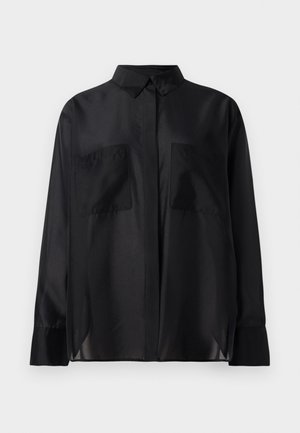 Chemise noire à manches longues avec col pointu, deux poches poitrine et manches à pattes sur fond blanc.