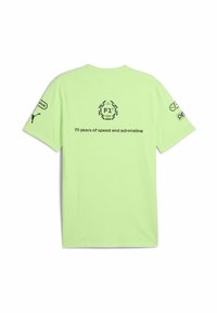 Lys grøn bomulds t-shirt med korte ærmer. Har et grafisk logo og tekst på ryggen: "75 år med fart og adrenalin."
