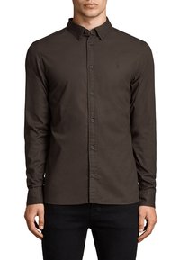 Camisa marrón de manga larga hecha de tela lisa con cuello abotonado, botones delanteros y un logo sutil en el pecho.