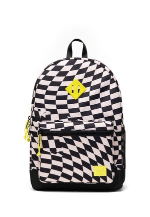 Sac à dos à carreaux noir et blanc avec motif ondulé, accents jaunes, poche zippée à l'avant et poignée noire sur le dessus.