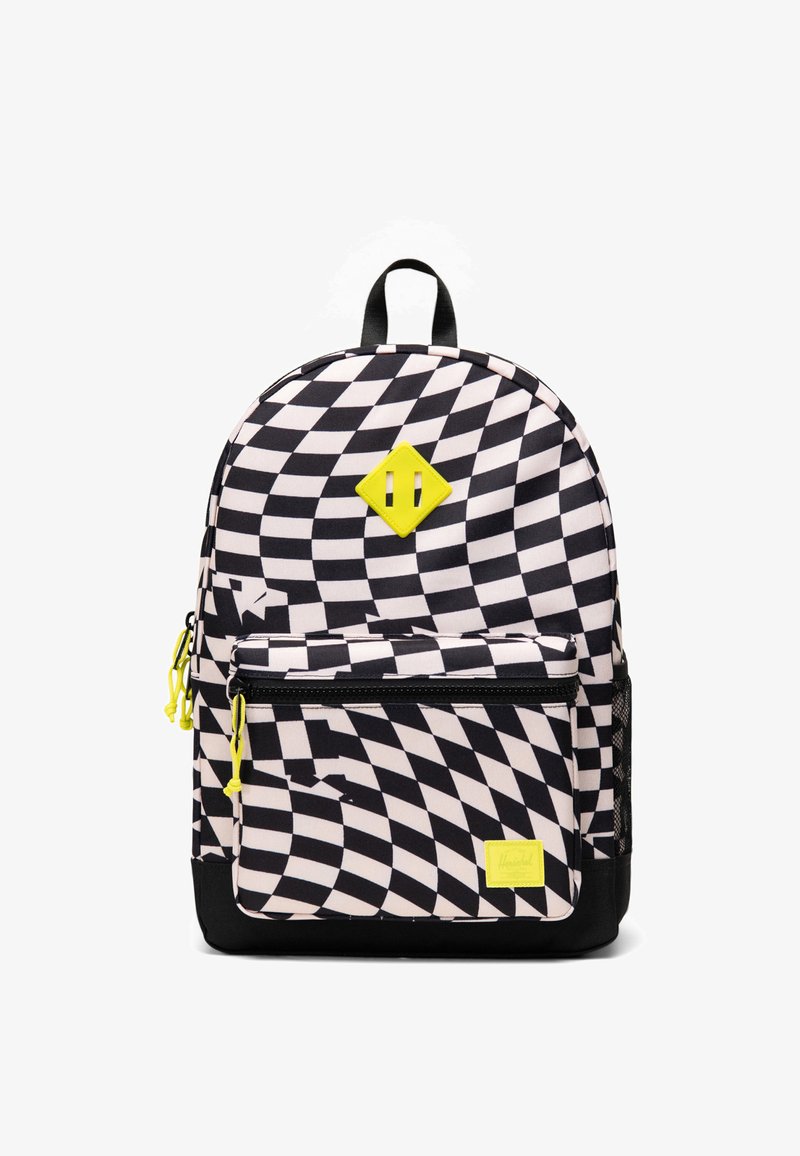 Sac à dos à carreaux noir et blanc avec motif ondulé, accents jaunes, poche zippée à l'avant et poignée noire sur le dessus.