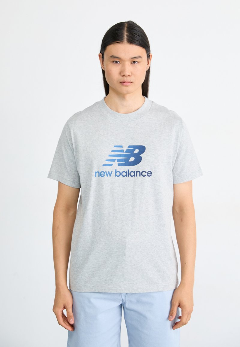 Gray cotton t-shirt featuring a blue "NB" logo and "new balance" text, short sleeves, and a crew neck design.