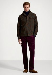 Brun mønstret skjortejakke med to brystlommer, kombinert med dype lilla kordfløyelbukser og brune loafers.