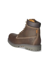 Bottine en cuir marron avec une semelle en caoutchouc gris robuste, lacée à l'avant, avec des accents cousus et un détail de marque sur le côté.