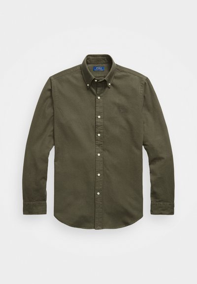 Oliwkowa koszula z długim rękawem i kołnierzykiem zapinanym na guziki, z białymi guzikami i małym logo na klatce piersiowej. Miękki, fakturowany materiał.