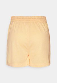 Pantaloni corti giallo chiaro realizzati in un tessuto morbido, con vita elasticizzata e fessure laterali all'orlo per facilitare il movimento.