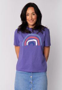 Paarse katoenen t-shirt met een regenboogafbeelding in rood, blauw en wit. Het shirt heeft een klassieke snit en korte mouwen.