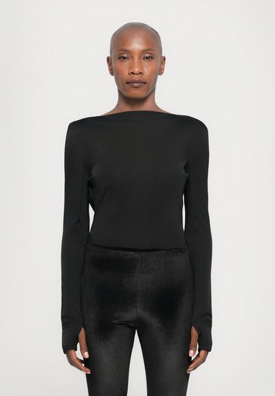 Black long-sleeve top with a wide neckline, made of smooth fabric, paired with high-waisted black leggings featuring a soft texture.