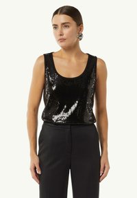 Czarna tank top z cekinami o okrągłym dekolcie i bezrękawowym fasonie, w połączeniu z czarnymi spodniami, wykazującymi błyszcząca, teksturowaną powierzchnię.