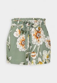 Pantaloni corti floreali in morbido tessuto verde, con una vita arricciata e una cintura annodata. Il tessuto presenta grandi motivi floreali arancioni e bianchi.