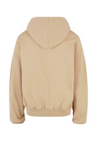 Sweat à capuche beige présenté de dos, avec manches longues et poignets et taille élastiques, sans logos ni motifs visibles.