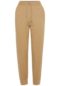 Beige træningsbukser lavet af blødt stof, med en elastisk talje og snørre, tapered manchetter og en glat overflade.