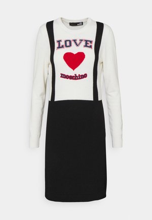 Langærmet kjole med hvid top, sort nederdelspanel, rødt hjerte og teksten "LOVE moschino" på brystet.