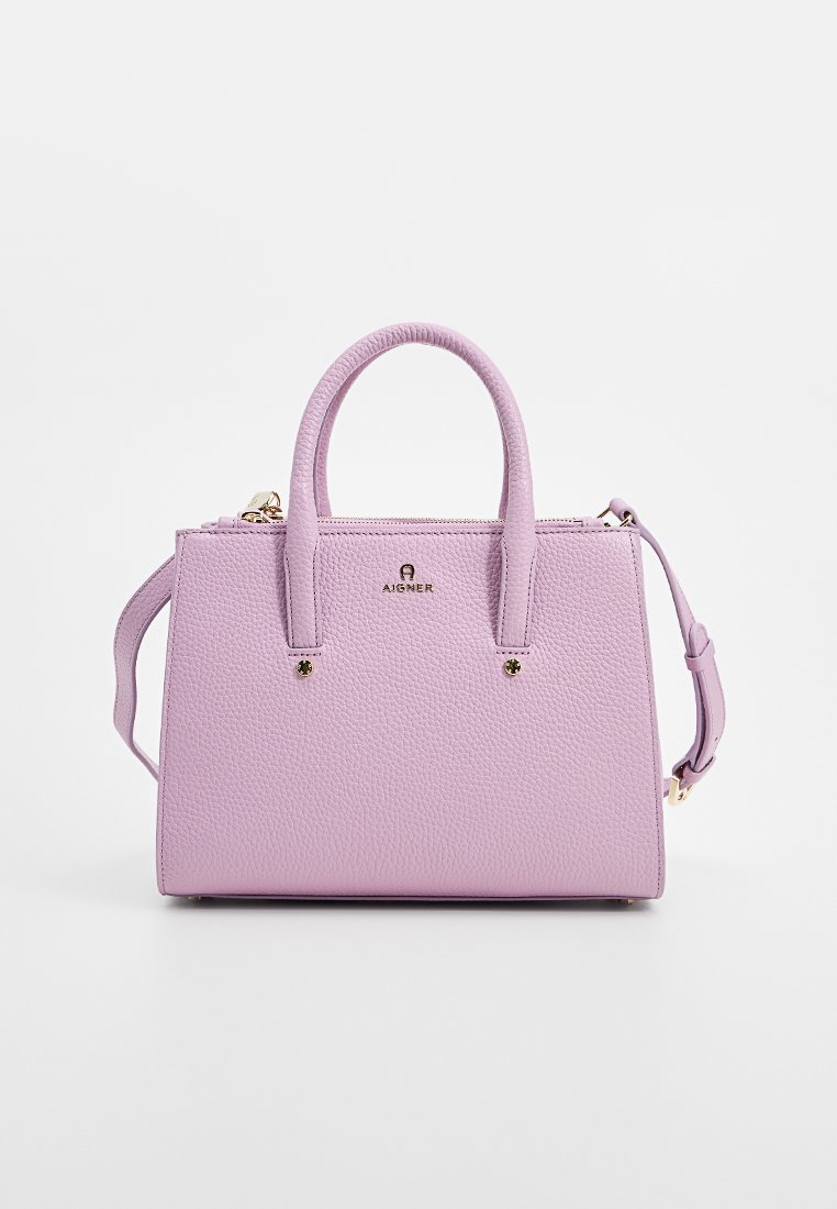 Kompakte Handtasche aus strukturiertem lilafarbenen Leder, ausgestattet mit zwei oberen Griffen und einem abnehmbaren Schultergurt. Goldfarbene Hardware-Akzente und Logodetail.
