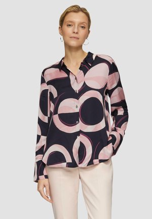 Camicia a maniche lunghe con bottoni di colore blu scuro decorata con motivi circolari rosa. Tessuto liscio, colletto classico e bottoni argentati.