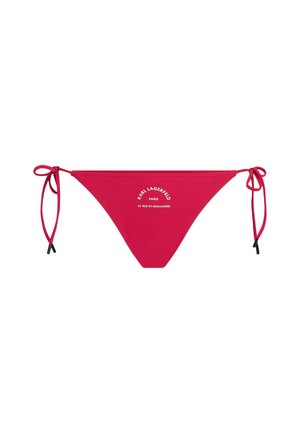 Parte inferior de bikini roja con lazos a los lados, con texto en relieve blanco y acentos negros. Tela suave, diseño minimalista y forma clásica.