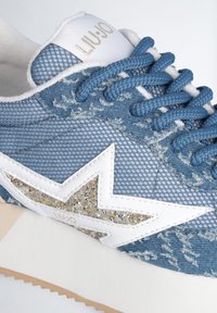Sneaker blu in rete con dettagli in pelle bianca, design a stella glitterata beige, lacci tondi e tessuto testurizzato per un tocco in più.