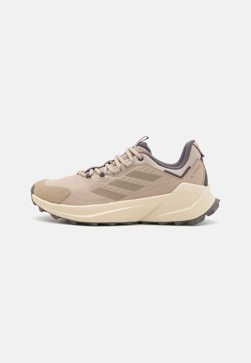 Beige Wanderschuh mit strukturiertem Obermaterial, grauen Akzenten und einer robusten Außensohle. Verfügt über einen gepolsterten Kragen und ein geschichtetes Design mit Schnürsenkeln.