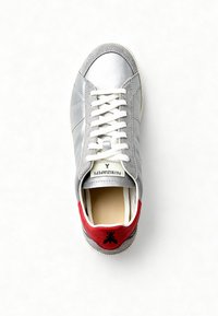 Zilveren leren sneaker met grijze suède accenten. Witte veters, rode hieltab met een zwart logo. Ronde neus en een getextureerde zool.