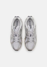 Hellgraue Sport Schuhe aus Mesh und synthetischem Material, mit Schnürdesign, gepolsterter Manschette und strukturiertem Sohlen.