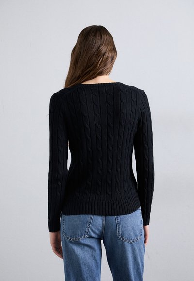 Black cable-knit sweater with long sleeves, ribbed hem, and textured design. Worn with blue high-waisted jeans, showing the back view.