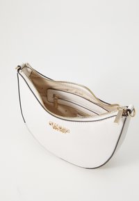 Borsa bianca con texture, caratterizzata da un design curvo, hardware dorato e un compartimento con zip con interno marchiato.