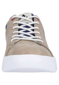 Beige suede sneaker with white rubber sole, gray accents near the tongue, and blue textile detail on the back. Features white laces.